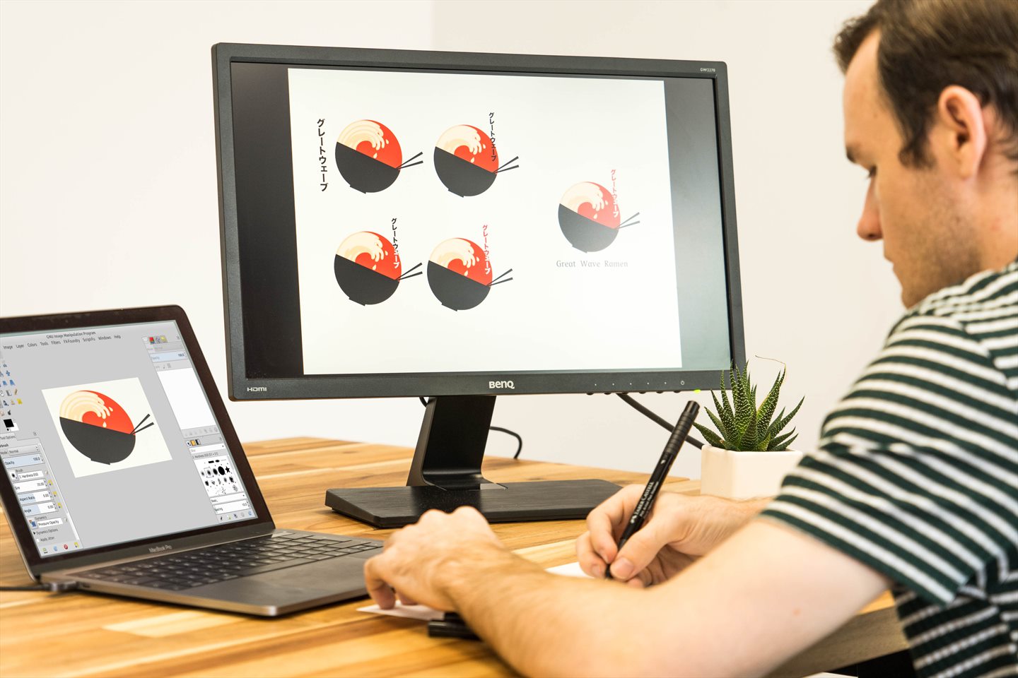 Nhà thiết kế đồ họa UI-UX phác thảo concept trên giấy và chỉnh sửa sản phẩm thiết kế trên màn hình đồ họa